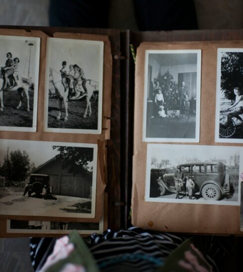 person opening photo album displaying grayscale photos