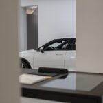 a white car is parked in a showroom